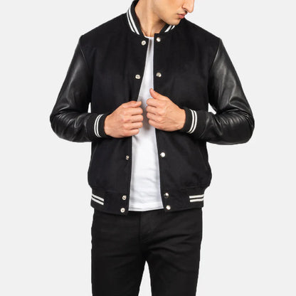 Person wearing a black varsity jacket with leather sleeves on a white background