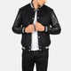 Person wearing a black varsity jacket with leather sleeves on a white background