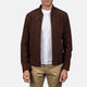 Man wearing a brown jacket over a white shirt and beige pants on a white background