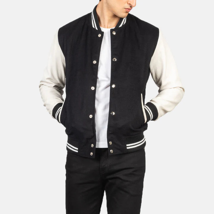 Black and white varsity jacket worn by a person on a light gray background
