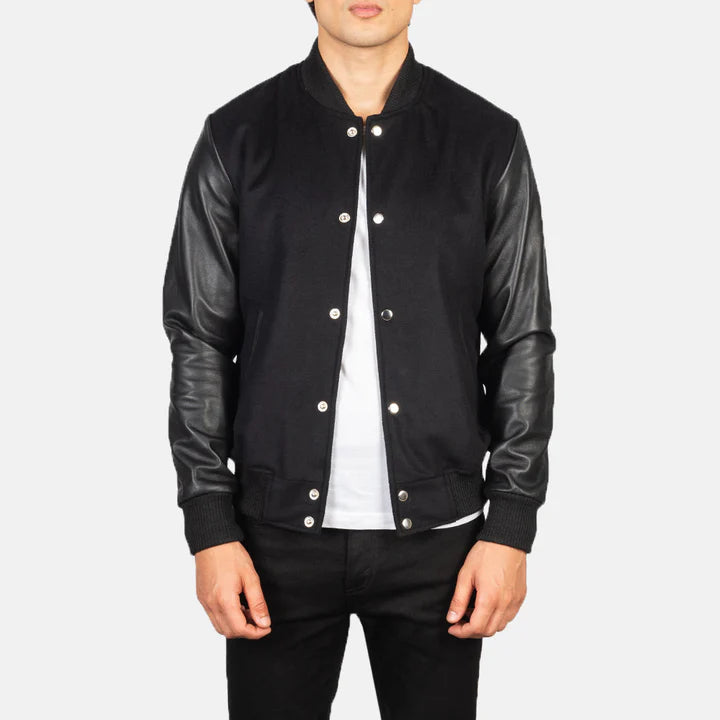 Black bomber jacket with leather sleeves worn by a person on a white background