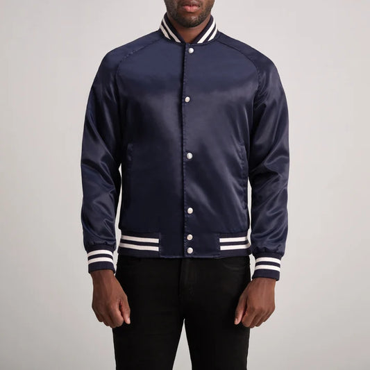 Navy blue varsity jacket with white accents worn by a person on a plain background