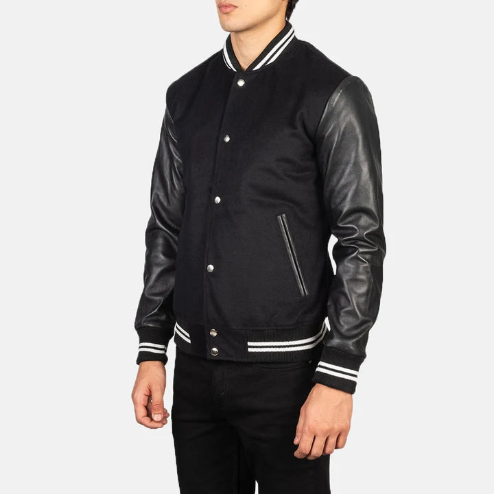 Black varsity jacket with leather sleeves on a white background