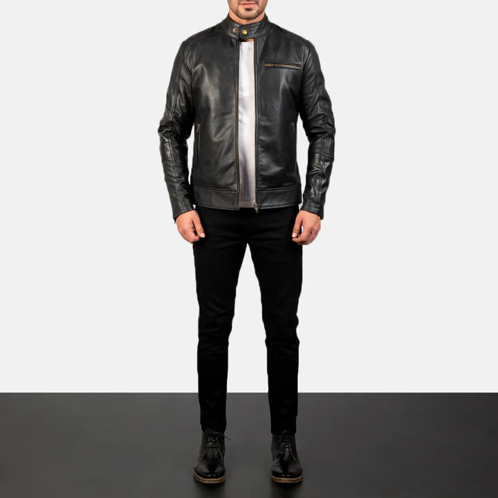 Person wearing a black leather jacket and pants on a plain background