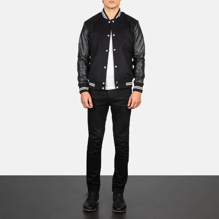 Person wearing a black varsity jacket with leather sleeves on a white background