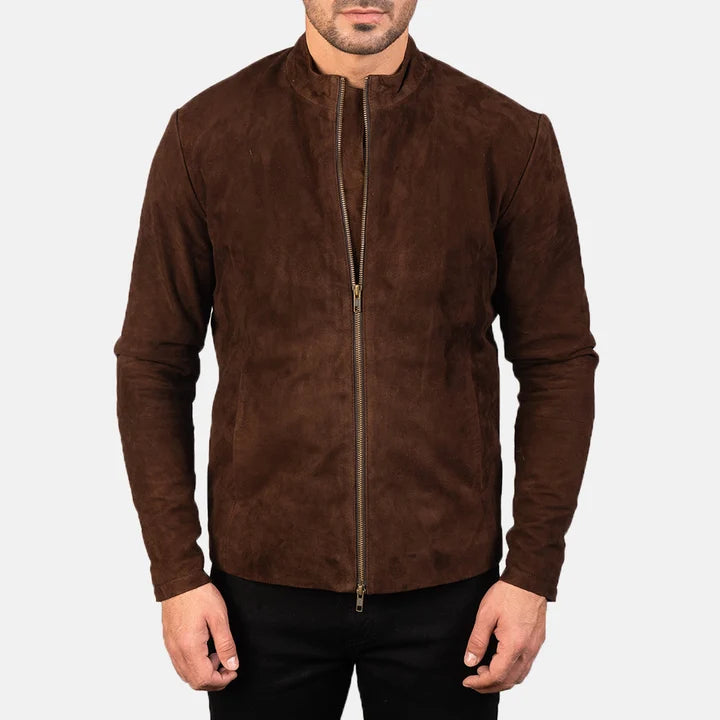 A man wearing a brown suede jacket with a stand-up collar and a front zipper, paired with black pants, against a light gray background.