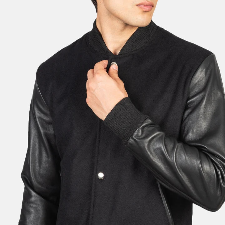 Black leather jacket with a man adjusting the collar on a light gray background