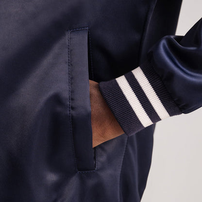 Navy blue jacket with a white stripe on the sleeve against a neutral background