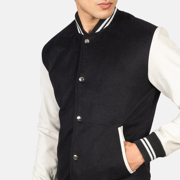 Black and white varsity jacket worn by a person on a plain background