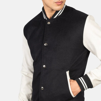 Black and white varsity jacket worn by a person on a plain background